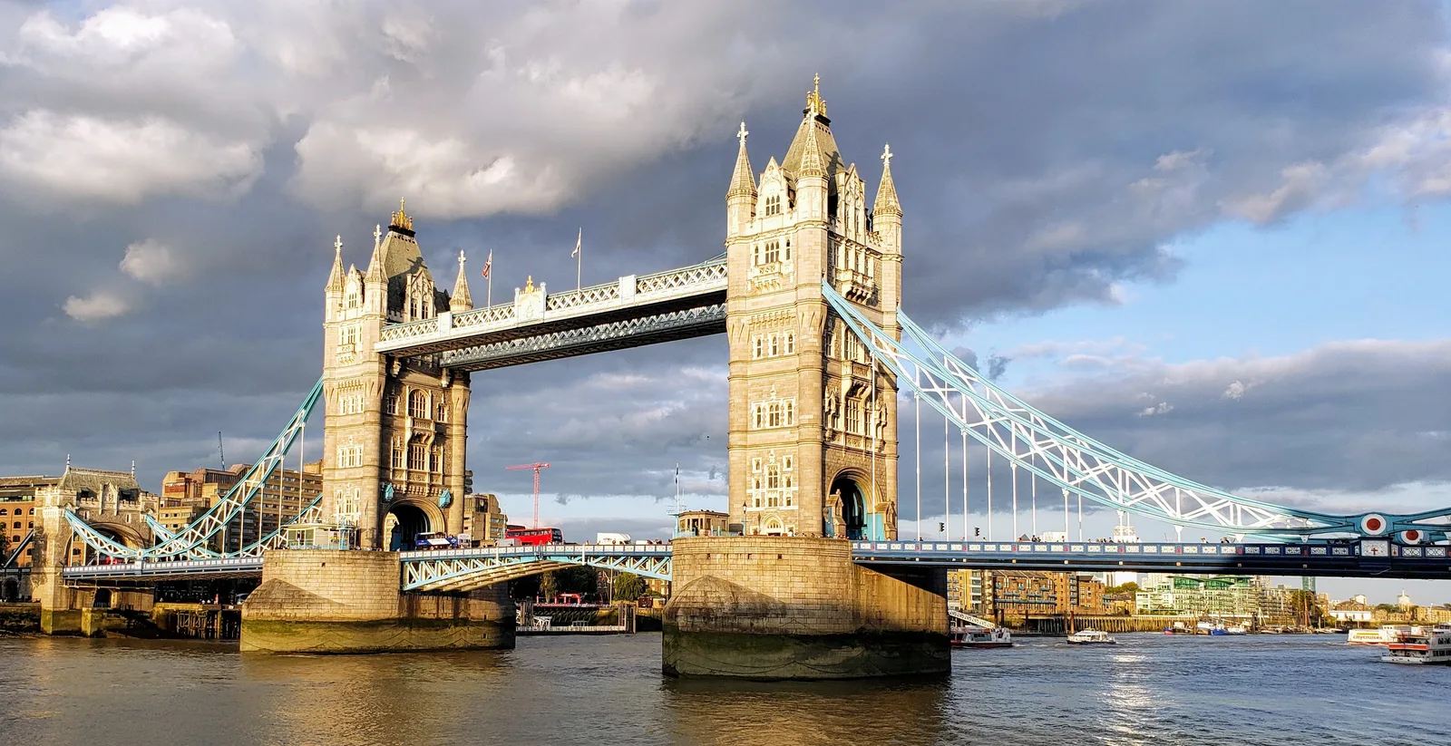 Tower Bridge over the Thames beneath a cloudy sky.